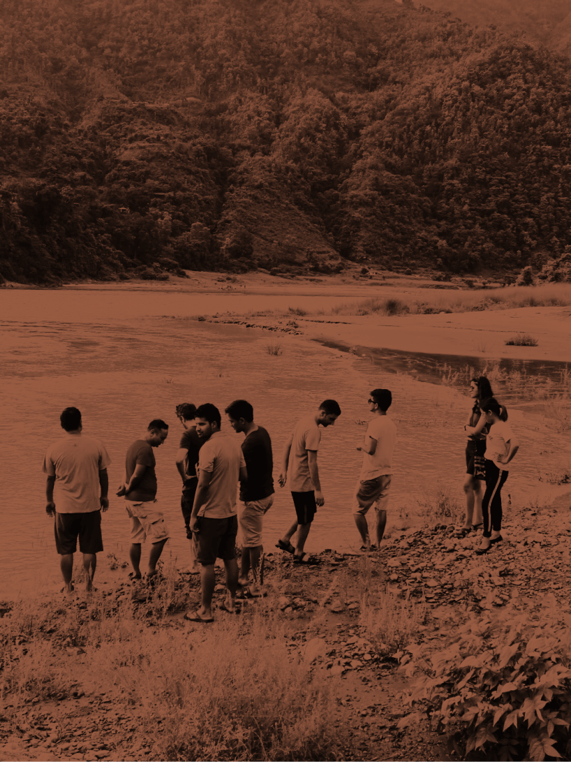 Outside team members standing by the river at an offsite event