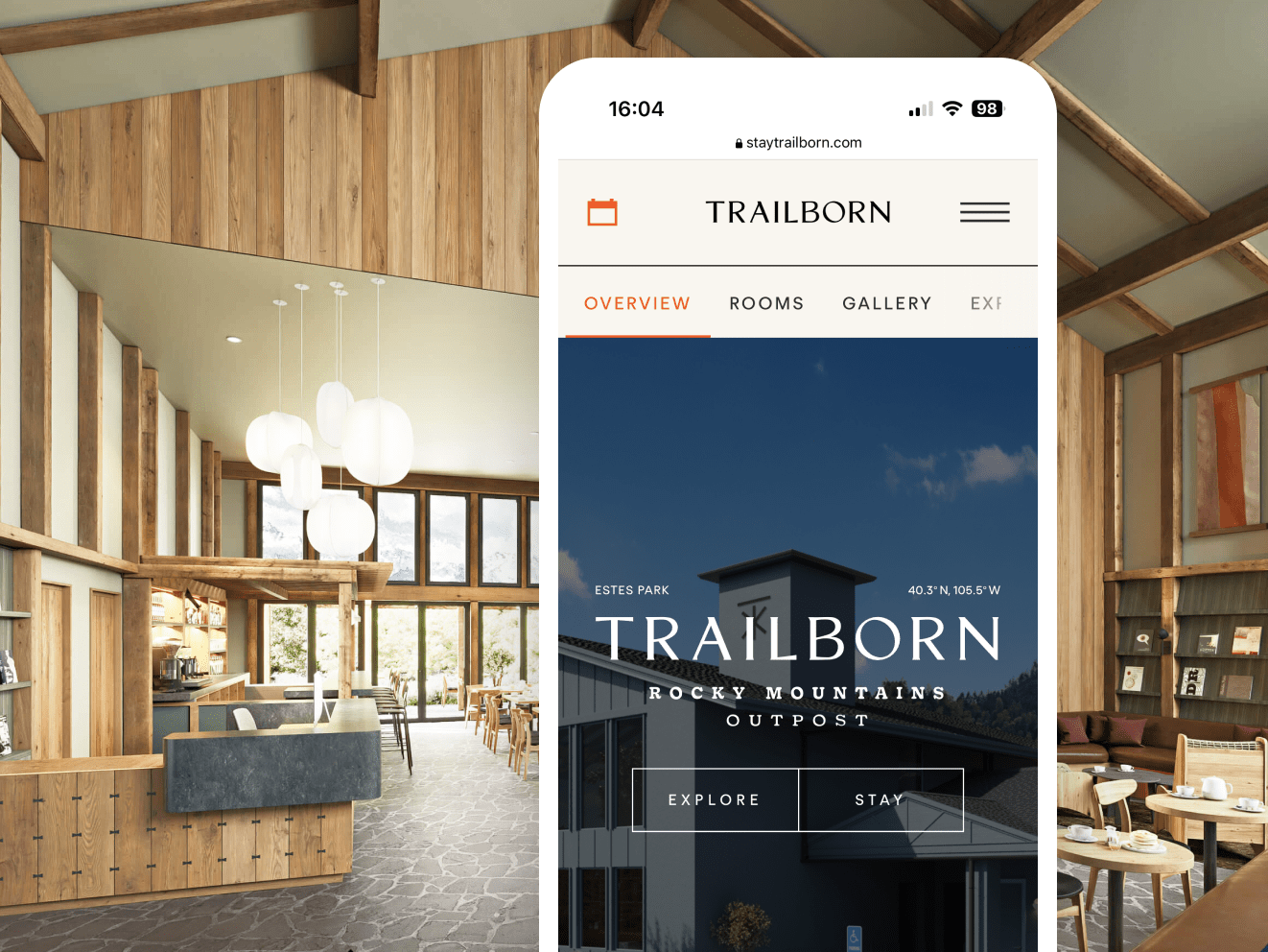 An iphone against the interior of a vacation home. Iphone screen shows the Trailborn app, with white text overlaid on a darkened image of a home and a blue sky. Buttons read &quot;Explore&quot; and &quot;Stay.&quot;